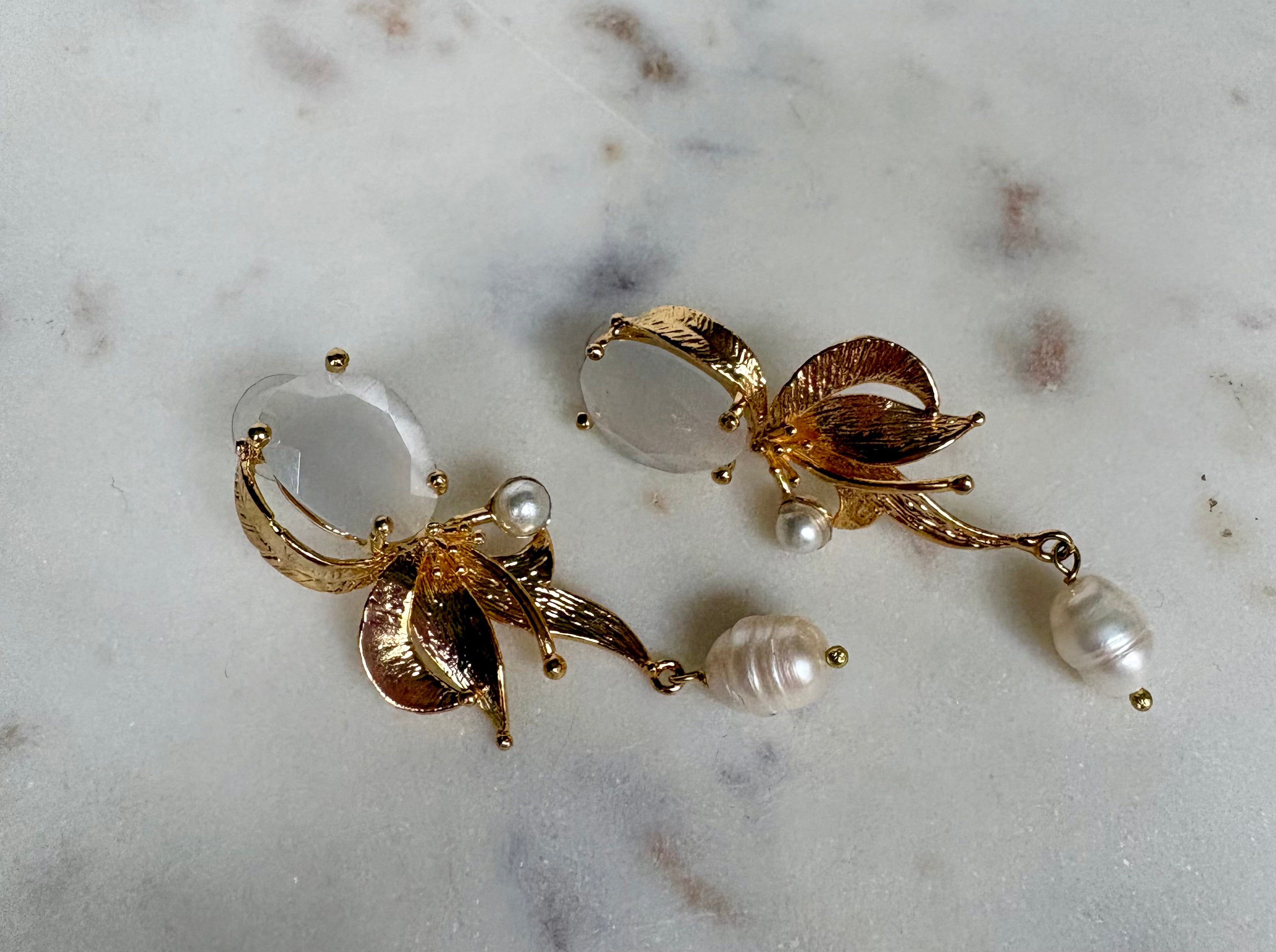 Gold earrings with white gemstone, leaf detail and pearl drop