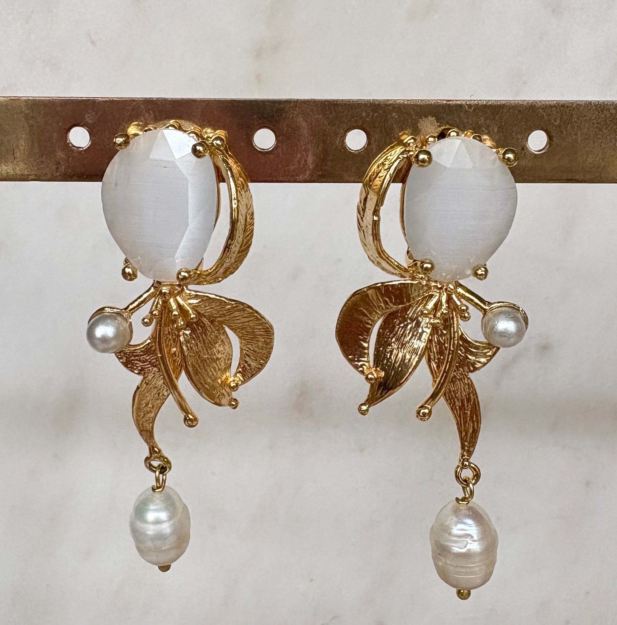 Gold earrings with white gemstone, leaf detail and pearl drop